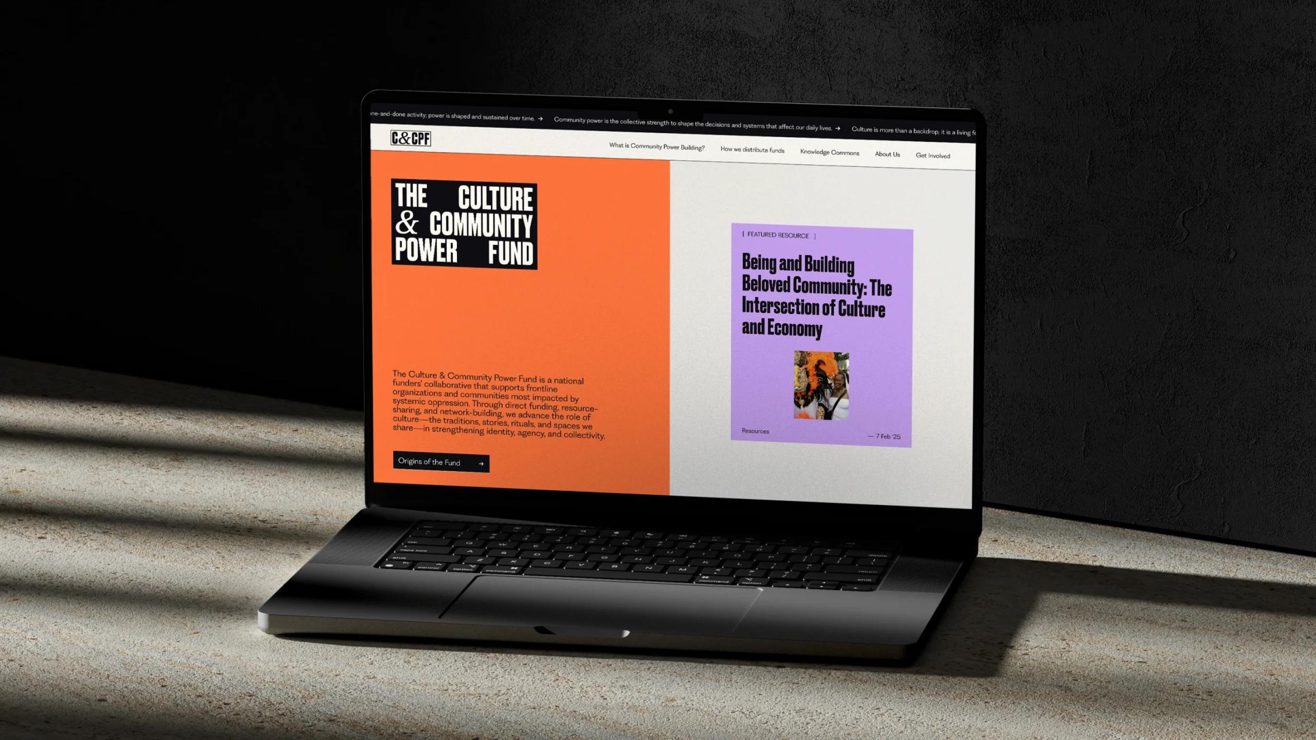 The orange, lilac, and white homepage of the Culture &amp; Community Power Fund on a laptop